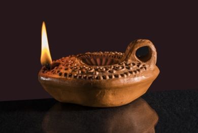 Vela antiga de barro com chama
