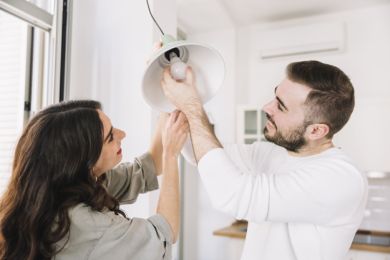Casal jovem a trocar uma lâmpada