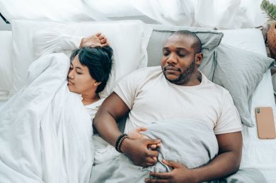 Casal jovem a dormir na cama